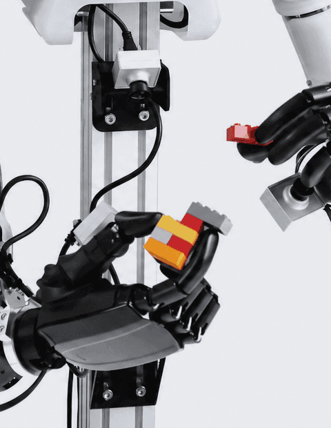 OpenARM robotic hand gripping a stack of toy bricks